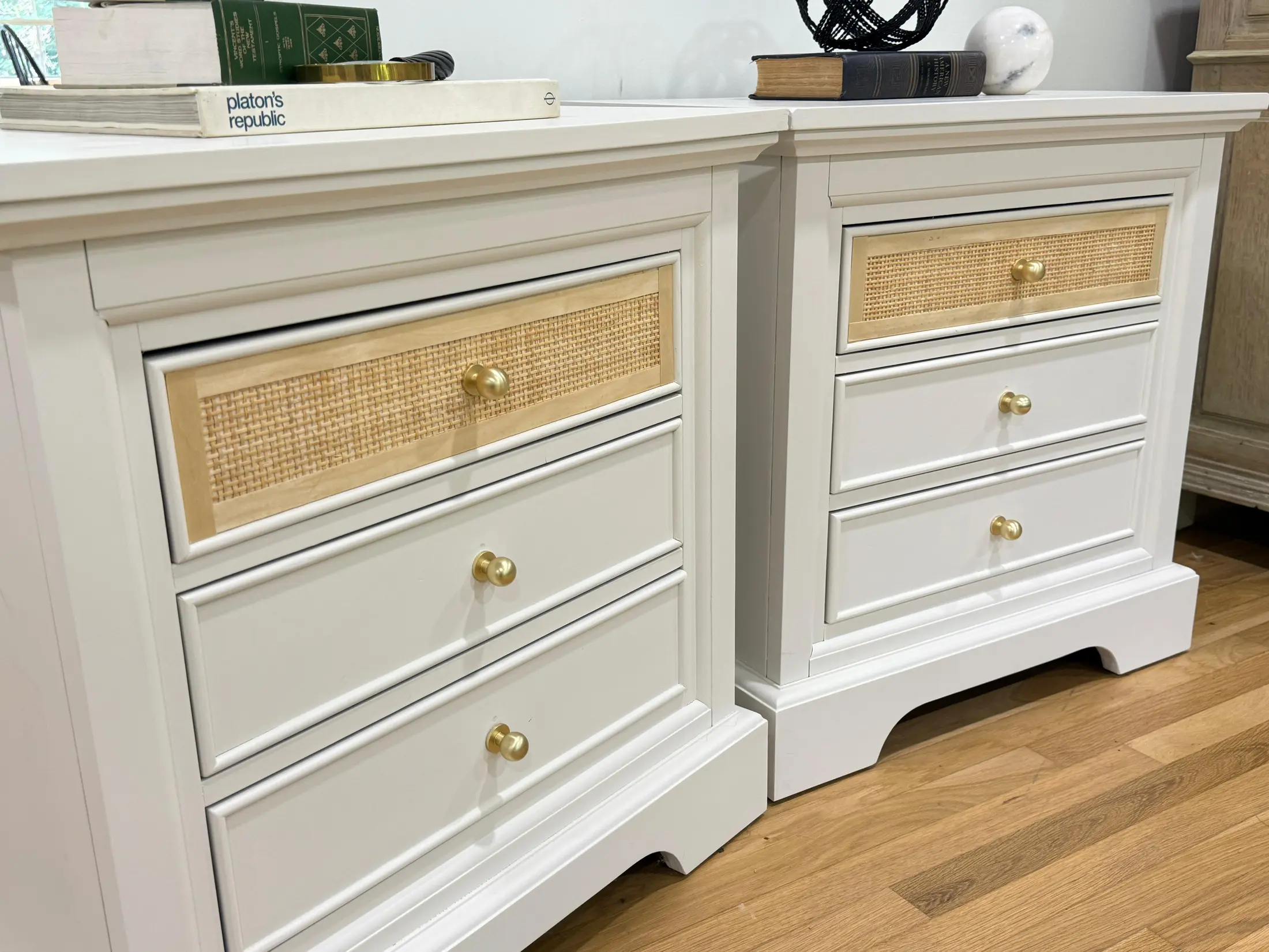 Pair of white nightstands with cane drawer fronts and brass knobs